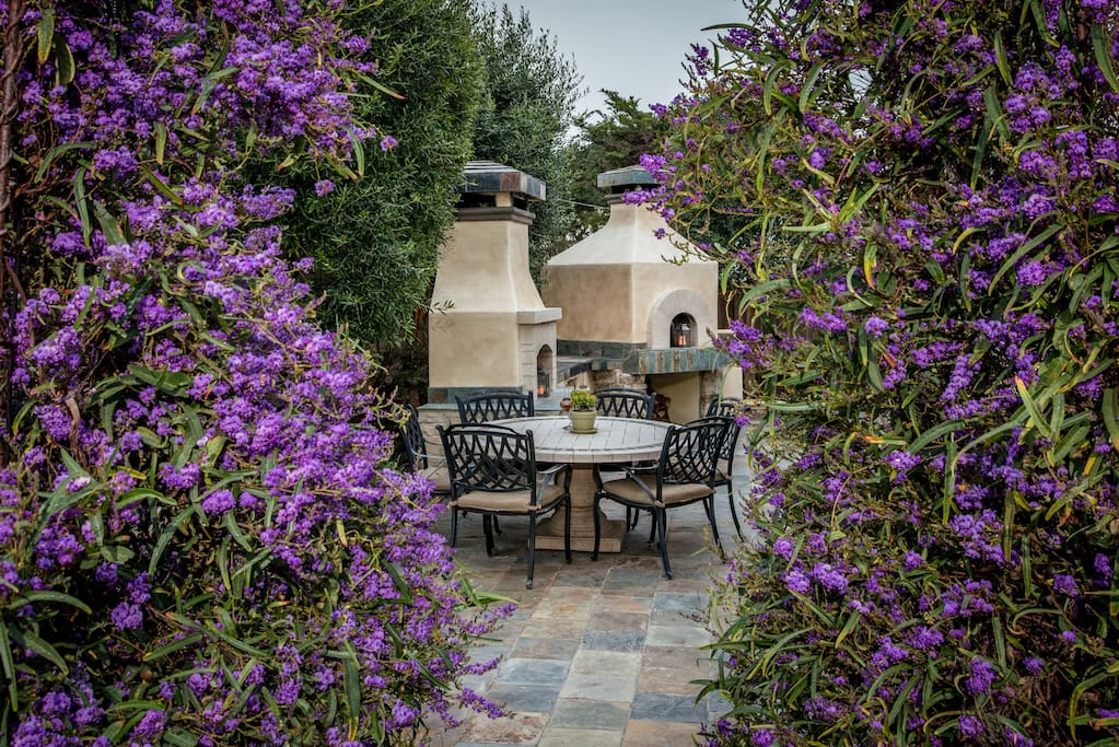 Lush gardens surround the private side patio with
a fire place and brick oven.