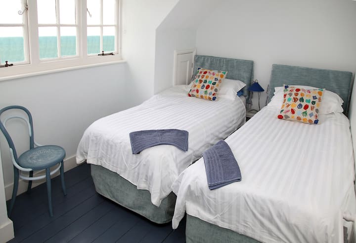Twin bedroom with delightful sea views, children’s toys, books and artworks. We can prepare this as an additional double bedroom if required