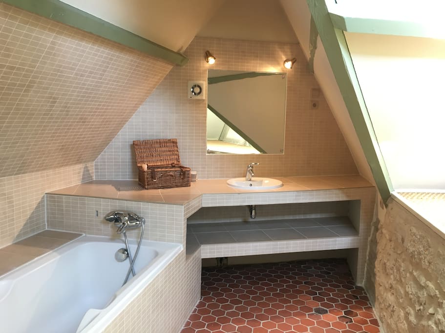 La salle de bain - très lumineuse - avec sa baignoire