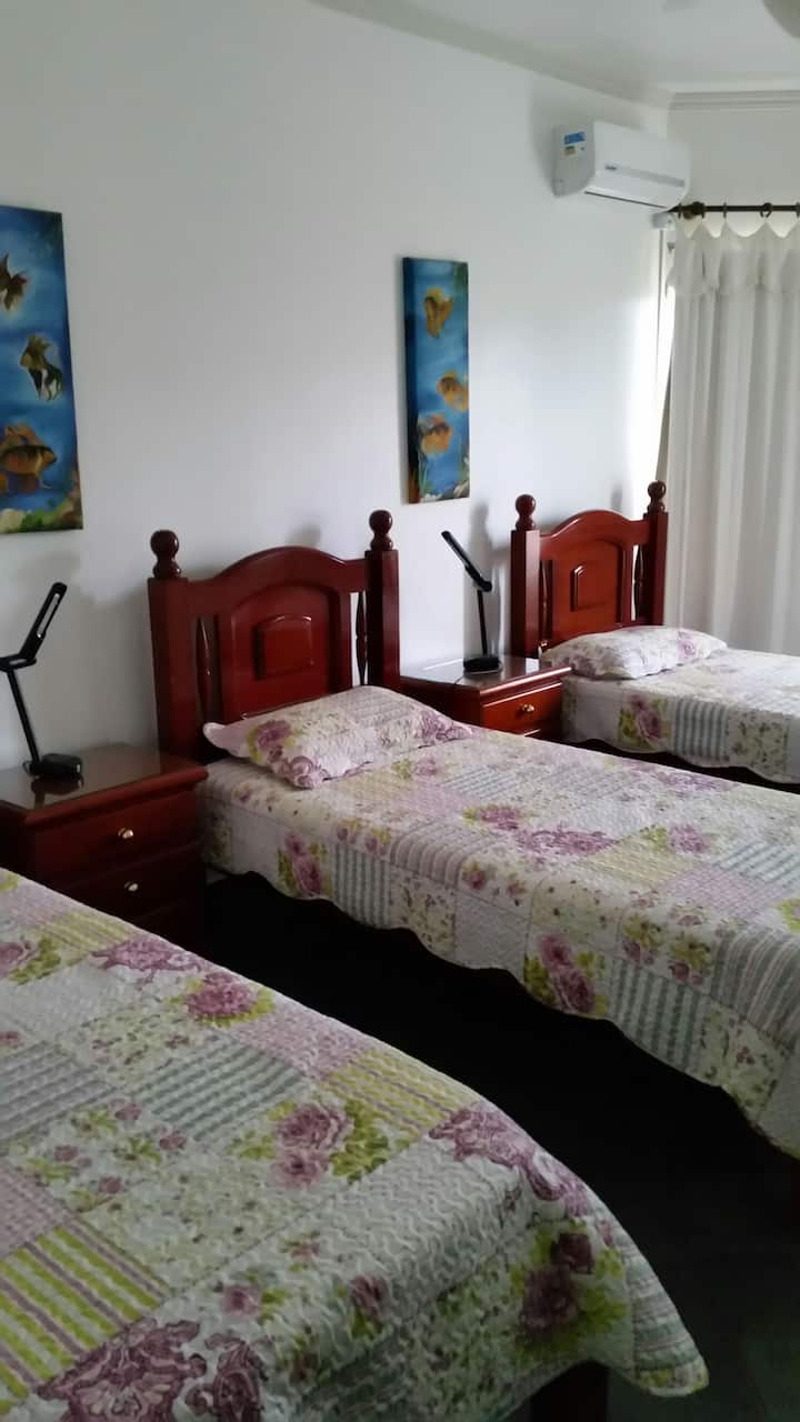 Chumba kimoja cha kulala. Vitanda vitatu, meza mbili kando ya kitanda, taa mbili kando ya kitanda, kabati la nguo , mito na kiyoyozi