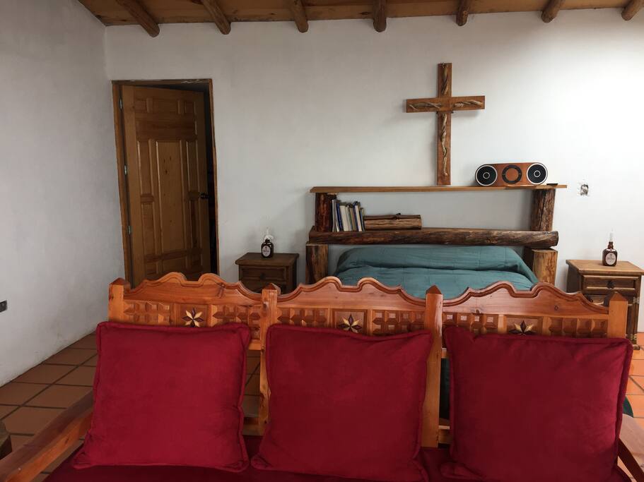 vista de entrada de frente a la cama con vista parcial al sofa, se aprecia ademas a entrada al bathroom