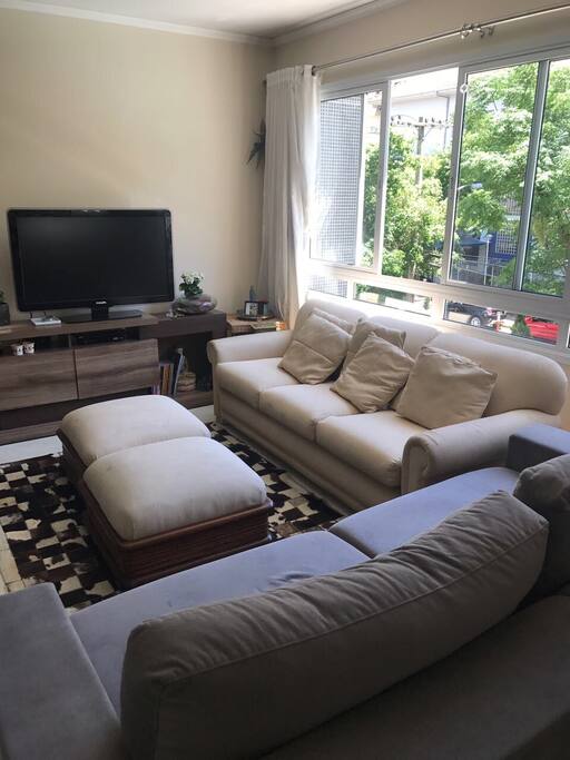 Sala de estar ampla, com sofás e televisão à cabo