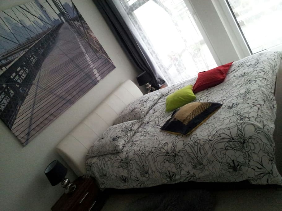 King size bed in a room separated from the living room.