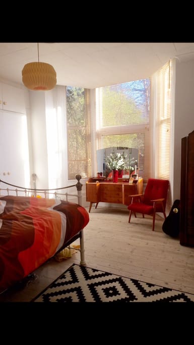 Warm bedroom with king sized bed and lots of light.