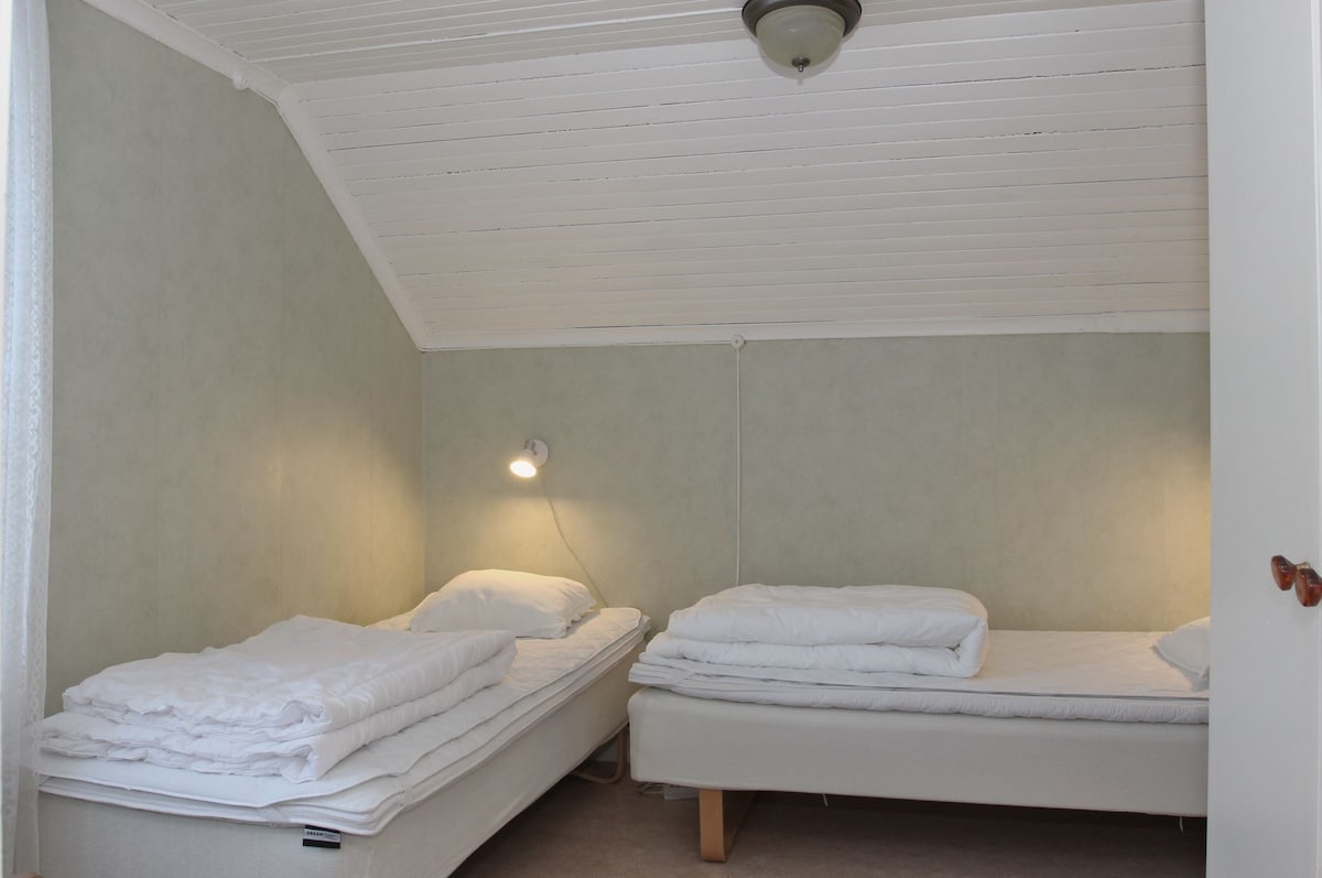 Мала спална соба со прозорец на исток. 2 кревета плус фотелја и мала маса.