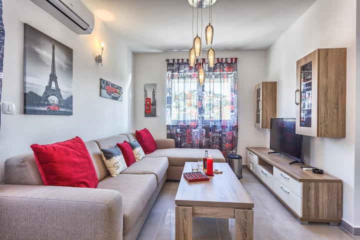 غرفة معيشة مع تلفزيون ذكي وسرير أريكة كبير