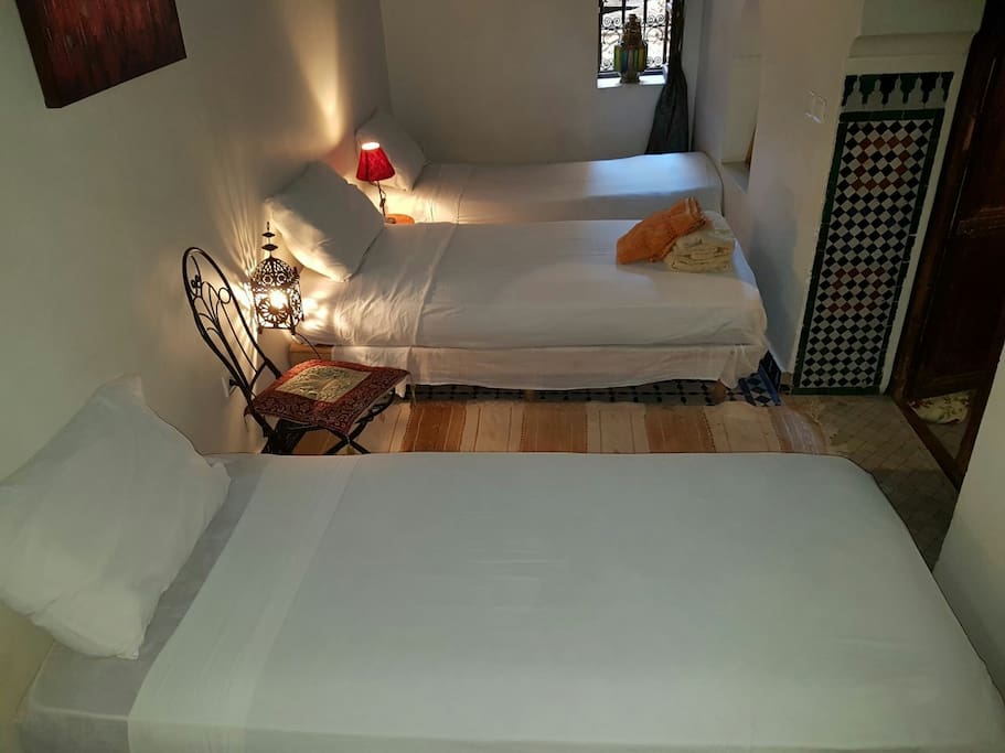 chambre avec trois lits pour trois personne climatisé, un grand salle de bain privé avec baignoire.
