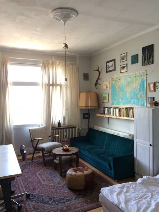 Cozy sofa corner with warm light and books and fruits.