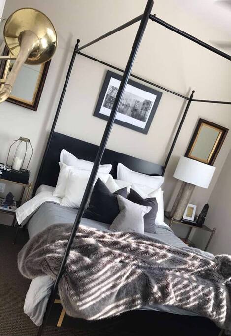 Luxurious furnishings including this custom-made queen canopy bed with Tuft & Needle mattress.