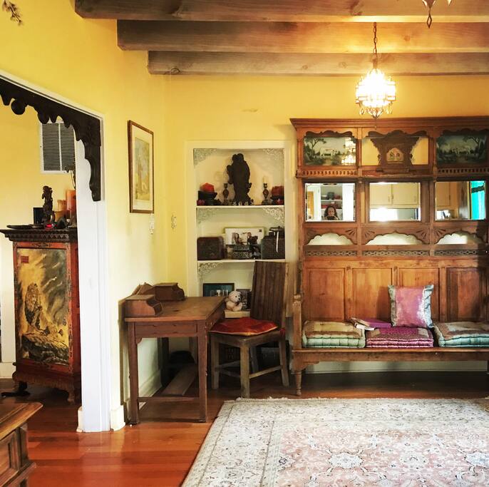 The dining room with a teak bench, a desks and Turkish lights hanging from the wood beam ceiling.