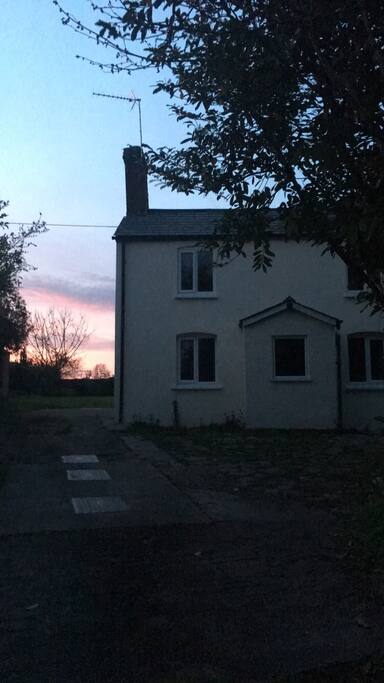 Cottage at sunset showing parking available