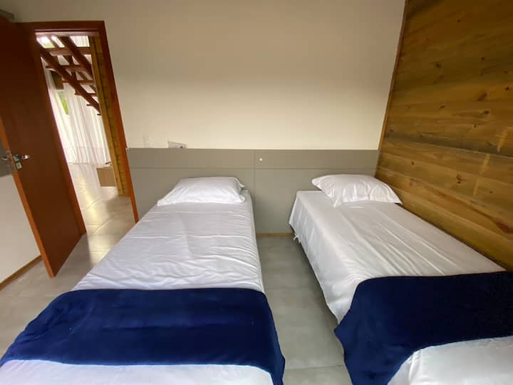Tercer dormitorio con dos camas nido, muebles hechos a medida, aire acondicionado, televisión inteligente, puerta con acceso externo que abre todas las hojas y apagón.
