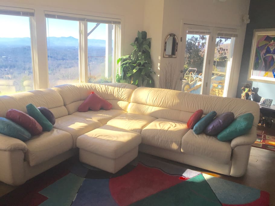 Suite with living room and panoramic windows, entertainment center, and french door entrance.