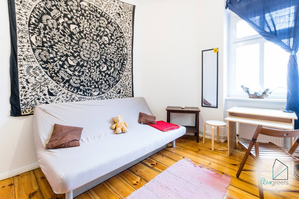 The combined living and sleeping room with beautiful wooden floor offers a comfortable sofa bed.
