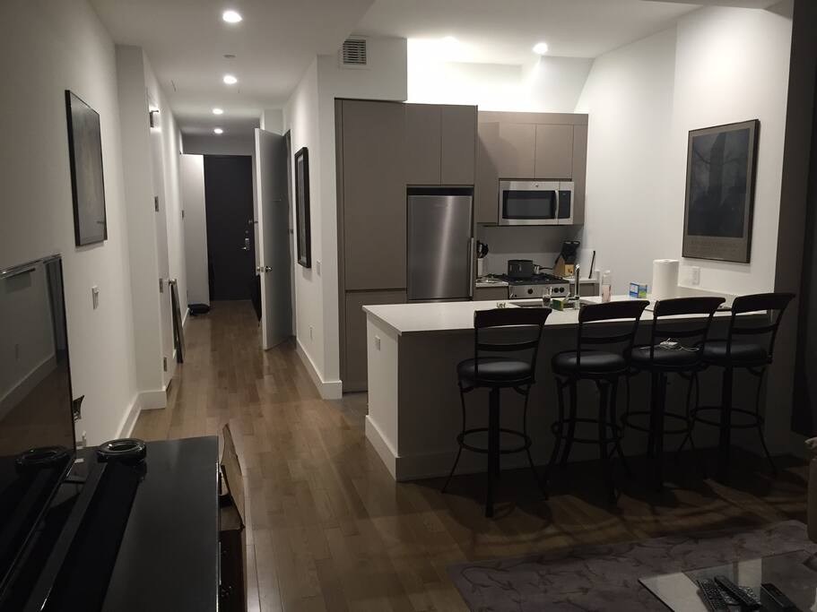 Modern kitchen fully stocked with plates, glasses, wine glasses, gas stove, pots/pans, etc