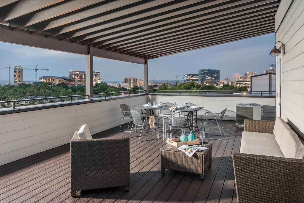 The covered rooftop deck boasts comfortable lounge furniture and a 6-seat patio table.