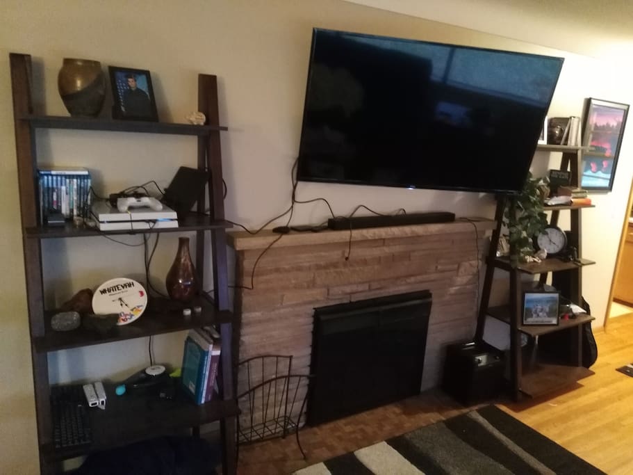 55" 4k Roku TV with electric fireplace in living room. 2 large four person couches in living room that could sleep individuals if needed (pillows and blankets provided to make that possible)
