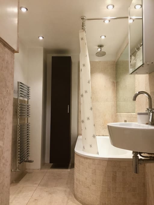 Private bathroom, with bath tube, shower and heated towel rail.
