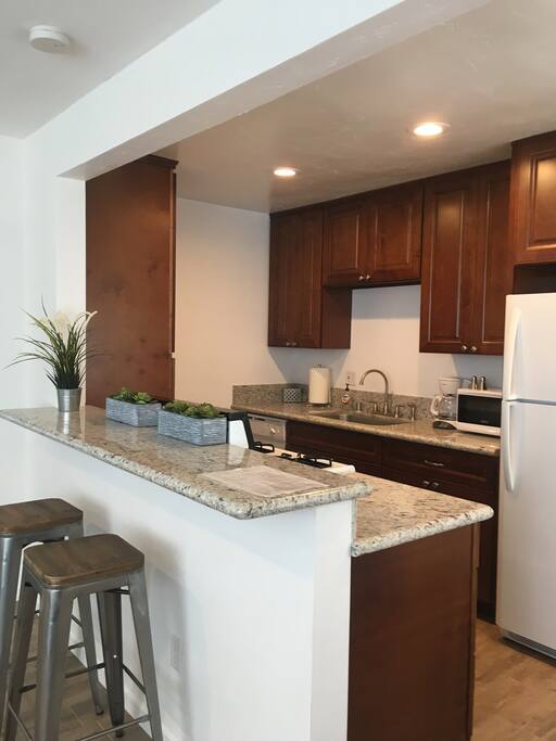 Kitchen is equipped with dishes, glasses, pots and pans, a coffee pot, microwave, toaster and blender as well as other essentials.