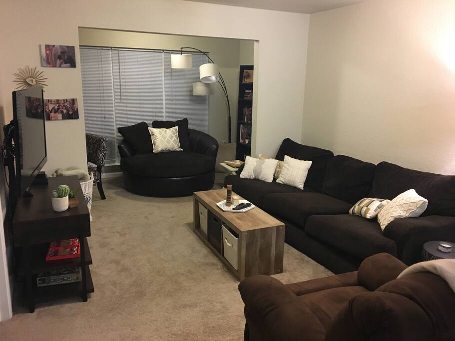 Living room with TV, a reading area with a bookcase, and a desk.
