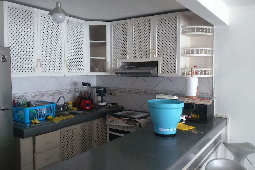 Cocina completa con extractor de grasa con repostero en 2 filas, bar con 3 sillas giratorias, y al lado su lavandería.