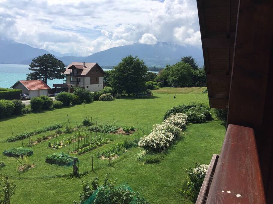 Vue du balcon sur le lac, les montagnes et le potager.