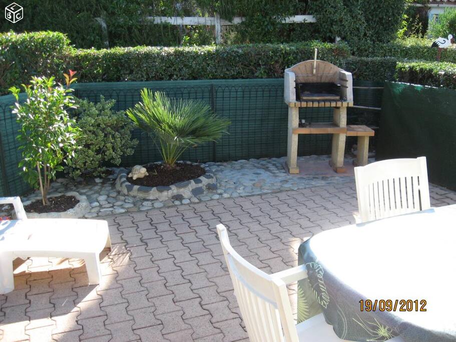 La terrasse avec salon de jardin et barbecue