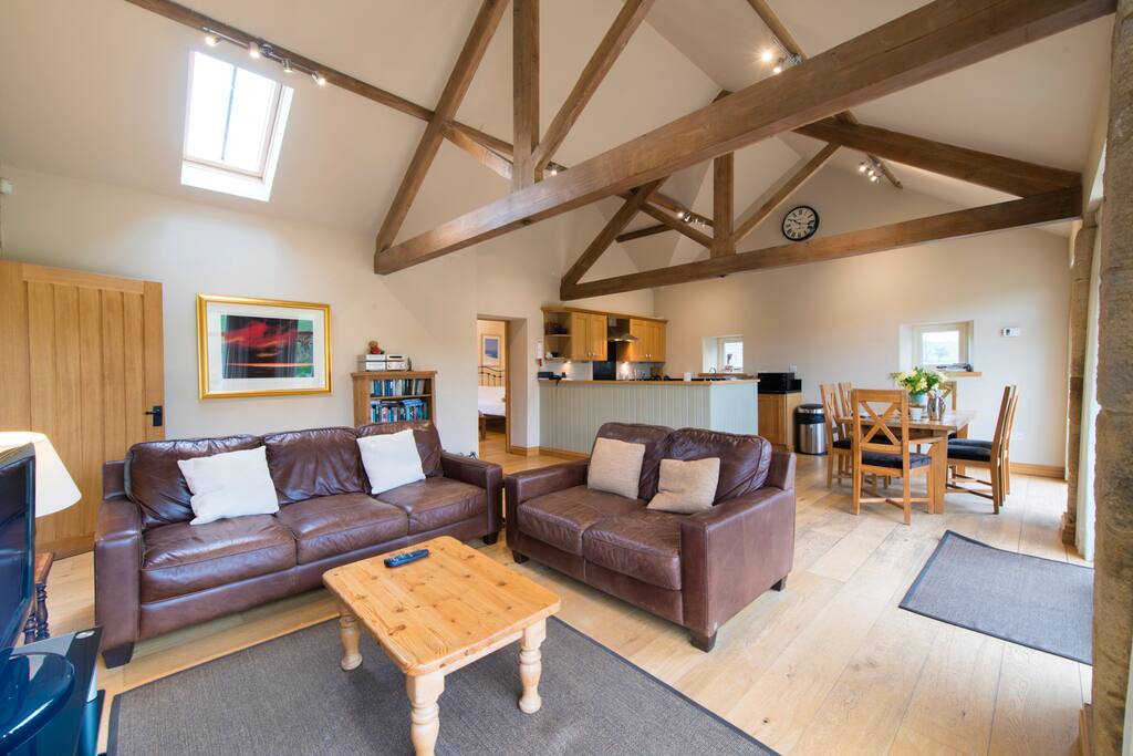 Lifestyle room with kitchen dining and lounge area complete with farmhouse style dining table and under floor heating.