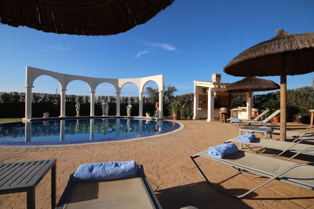 Pool area with sun beds and parasol