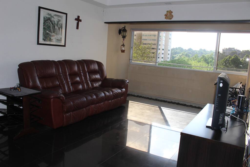 Couch at the living room with cable TV and electric fans.