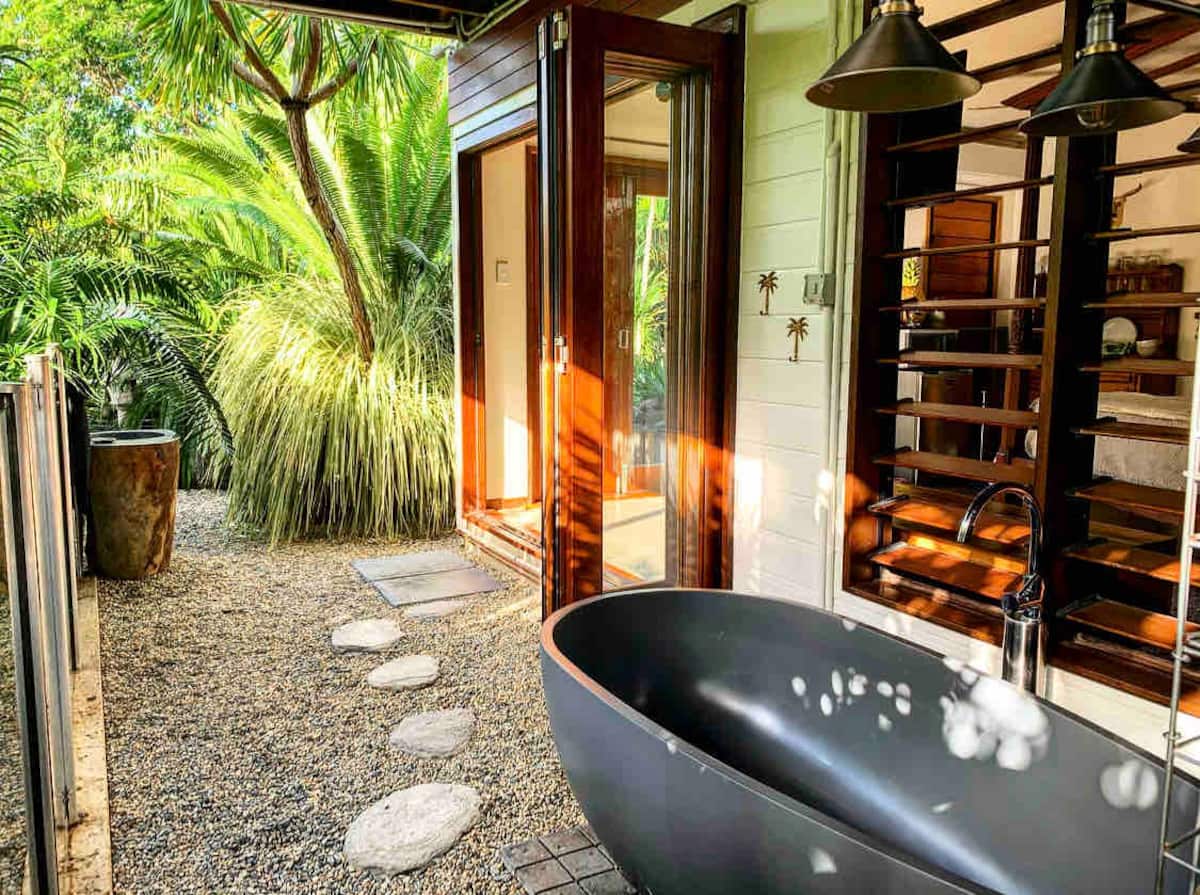 Outdoor bath surrounded by greenery in Lily Pad Inn, Cairns North