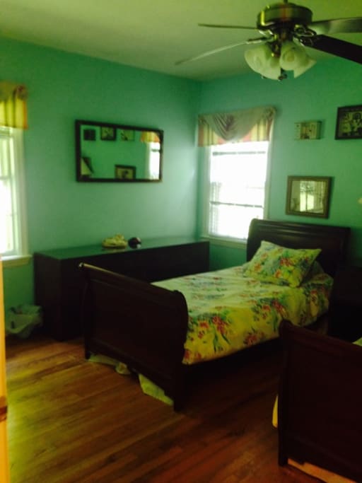 A view of the Aqua Room at Hospitality Sweets @ Leah's showing the light from the 2 windows and the mirror above the dresser between the windows. A ceiling fan allows for optimum comfort.