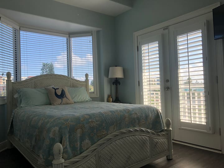 El dormitorio de invitados con cama tamaño Queen en el tercer piso ofrece un pequeño balcón privado.