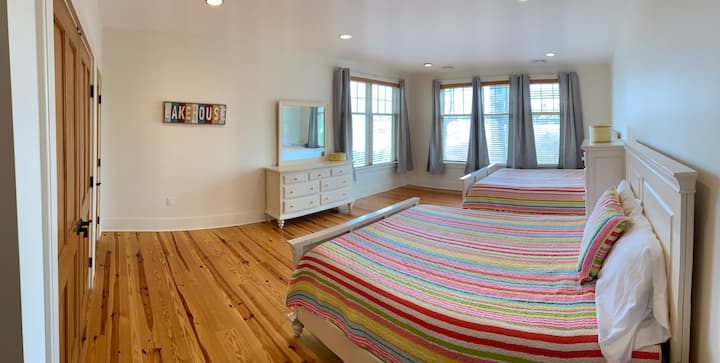 Guest room located on the lower level of the house with 2 queen beds. This room has a very "beachy" feel to it with its white furniture and large windows facing the water.