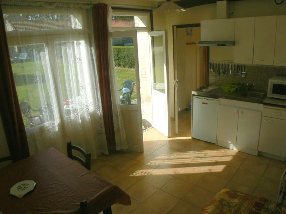 Séjour, à gauche la terrasse, à droite la cuisine équipée