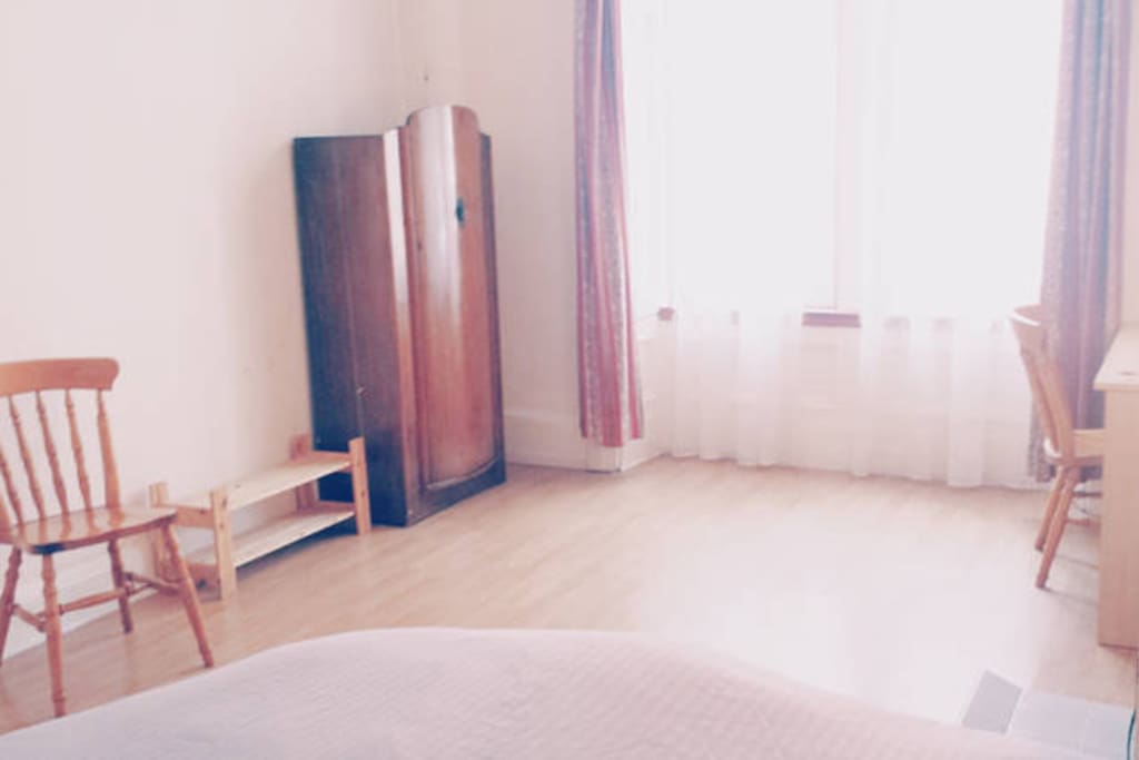 Spacious bedroom, wooden furniture.