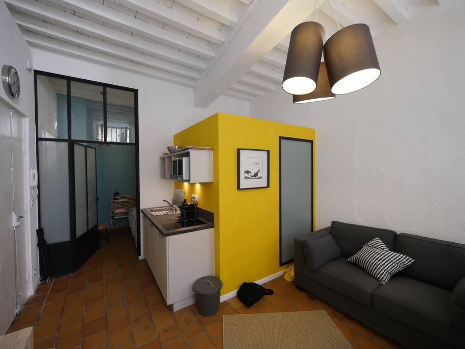 Coin cuisine et canapé convertible. En arrière plan, la chambre. Living room and kitchen corner
