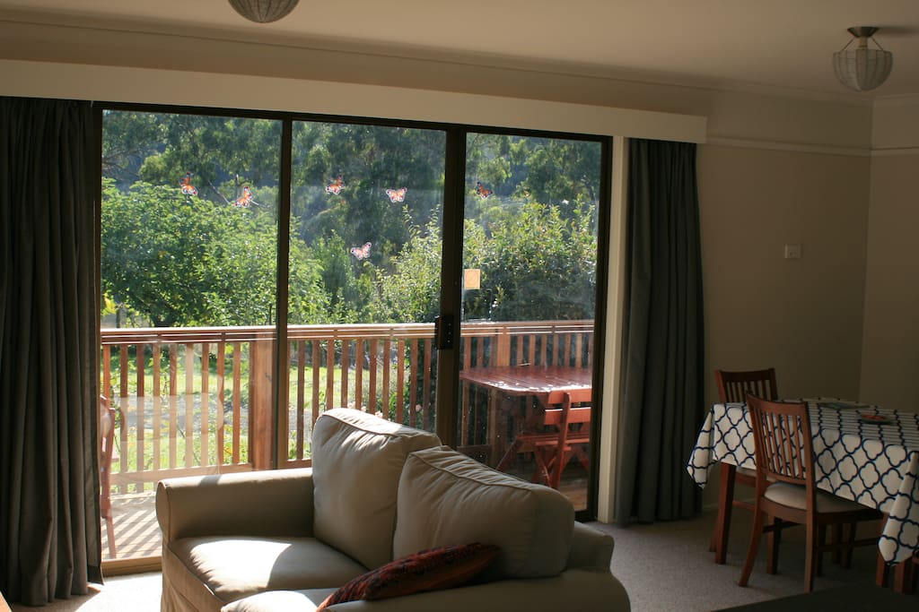Shot from the kitchen looking across the living/dining area to the deck and garden
