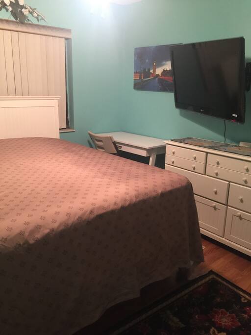 Private room with king sized bed with a double pillow top mattress, retractable 1080 HDTV TV, dresser and desk.