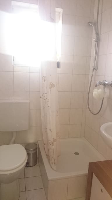 Kleines Duschbad mit Fenster, WC, Waschbecken, Spiegel, Fön und Regal