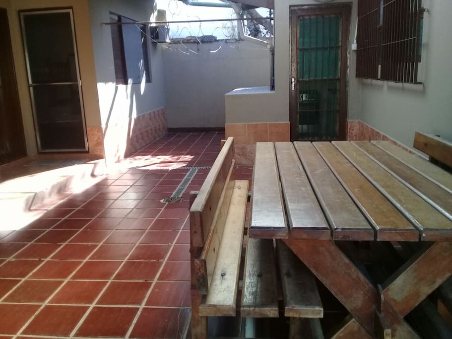 Área externa com mesa de bilhar, churrasqueira, tanque e pia de apoio.