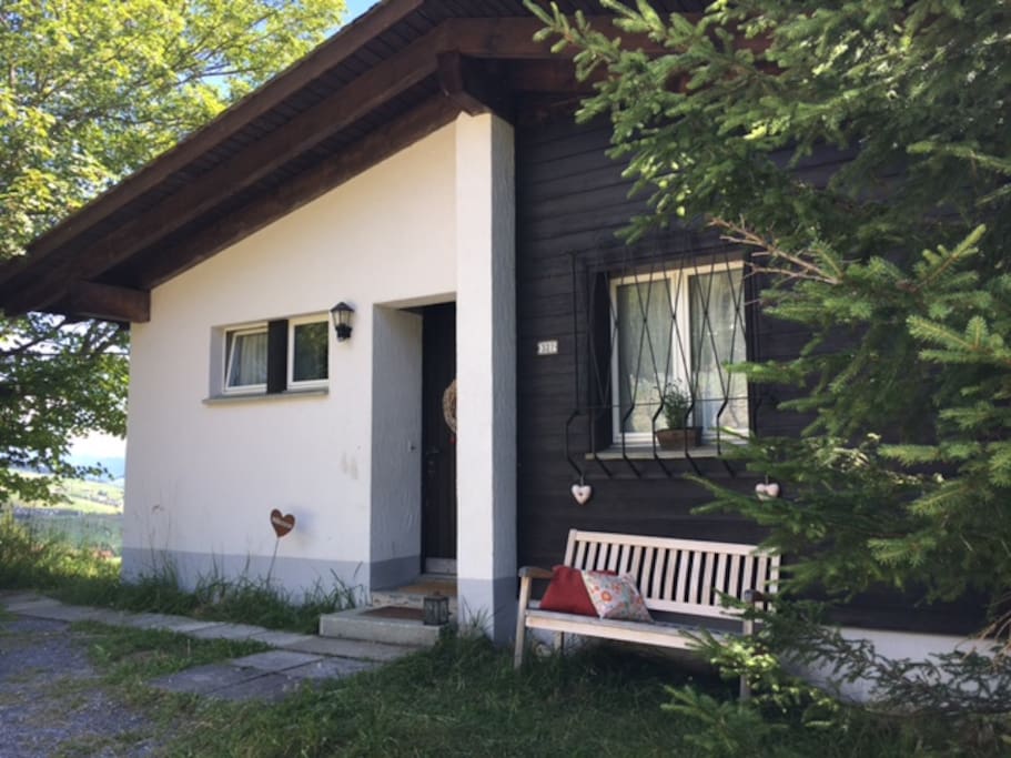 Eingang mit "Abendsonnenbank" und privatem Parkplatz
