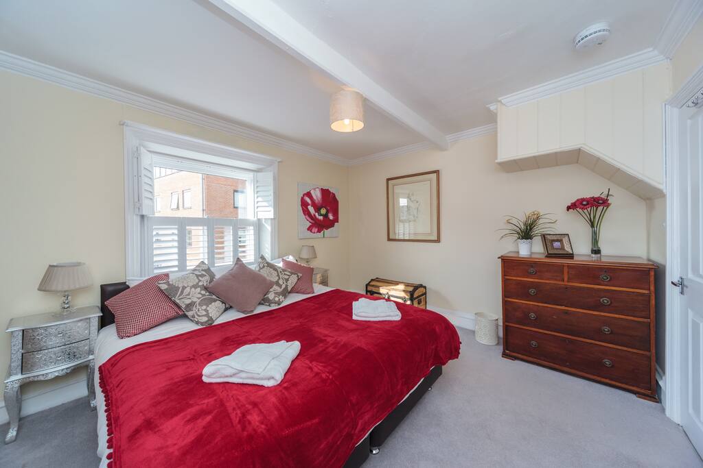 With hotel style zip and link beds this bedroom can be kingsize double or two singles. We love the shutters and the antique chest of drawers