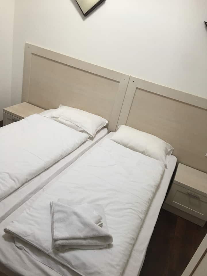 Dvokrevetna soba na prvom katu - dva kreveta za jednu osobu, dva noćna ormarića, mali ormar, komoda i ogledalo. 