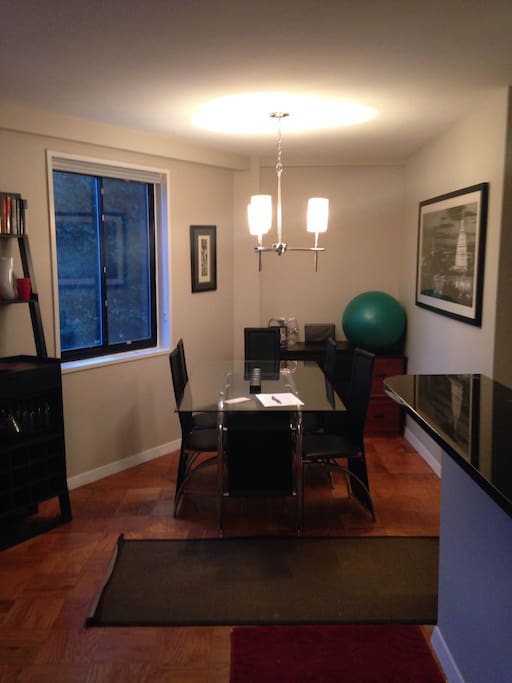 Separate living area with dining table and six chairs. Window looking out onto Embassies of New Hampshire Ave.
