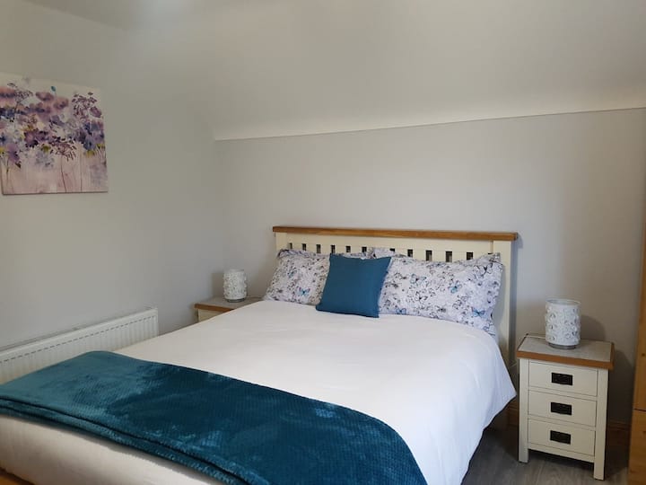 Kitanda cha ukubwa wa King kilicho na mashuka na matandiko yote.