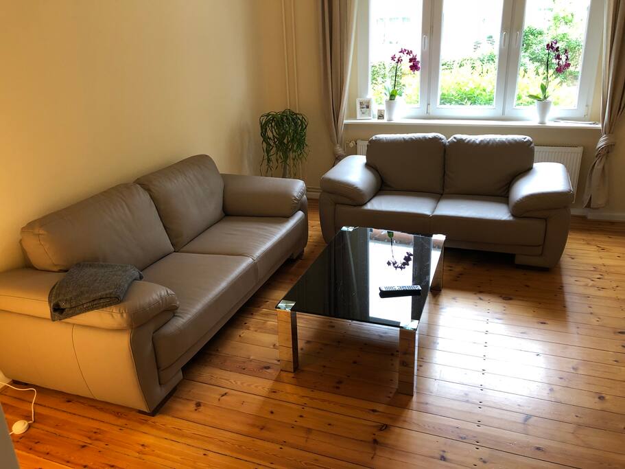 Wohnzimmer mit hochwertigen Ledersofas und Design-Glastisch