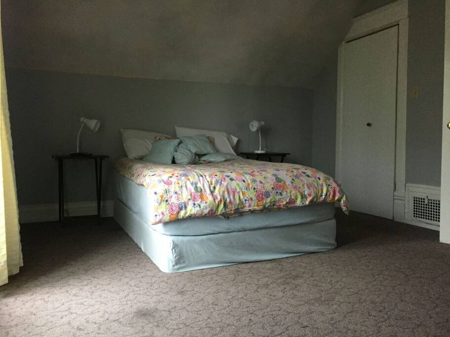 Bright bedroom with large closet and small balcony.