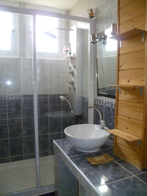 Une grande douche ou la température est réglable très facilement et des étagères pour le rangement