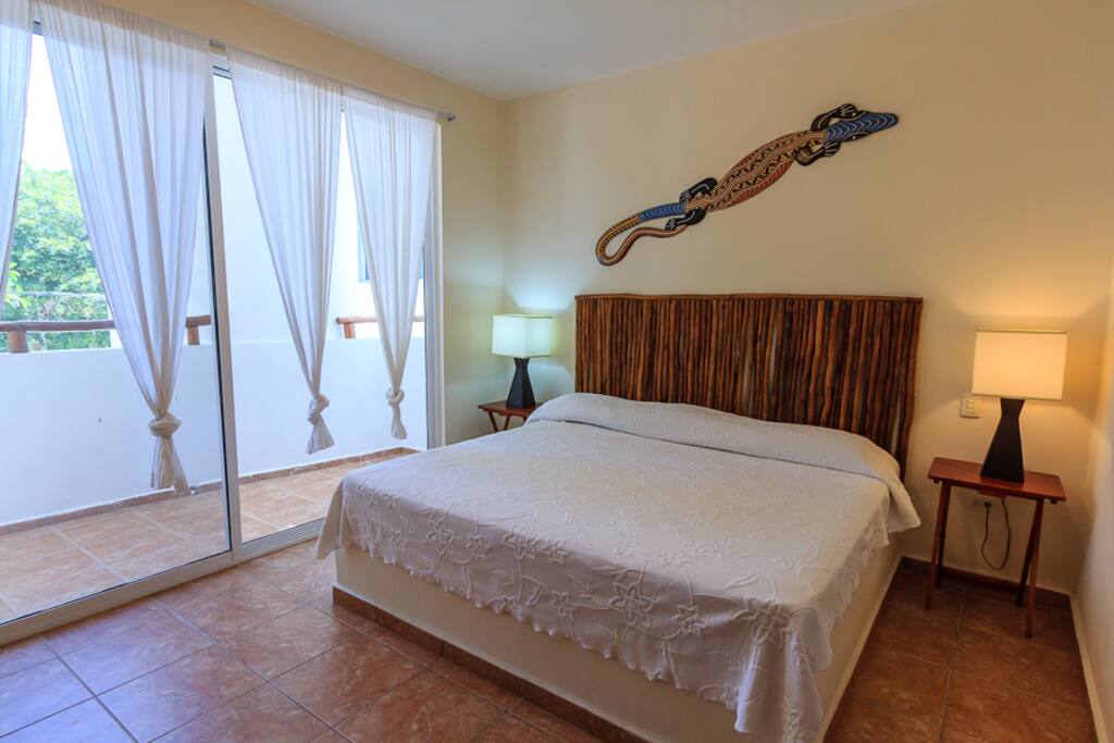 Master bedroom with sliding doors to balcony at front of house.